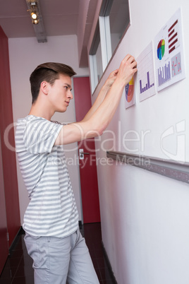 Student putting graphics on the wall