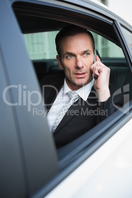 Serious businessman using his phone