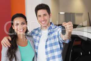 Smiling couple holding their new car key