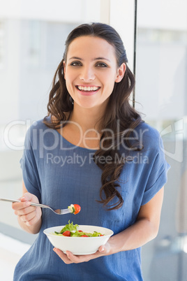 Pretty brunette eating a salad