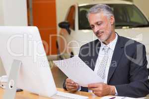 Businessman reading document at office desk