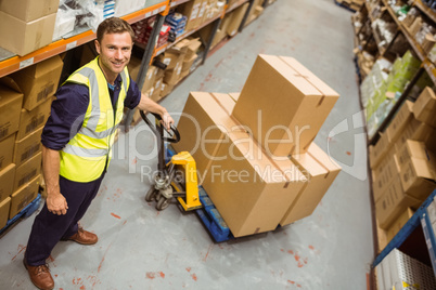 Worker with trolley of boxes smiling at camera