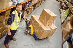 Worker with trolley of boxes smiling at camera