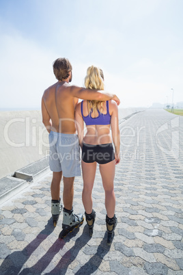 Fit couple rollerblading together on the promenade