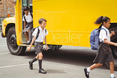 Cute schoolchildren getting off the school bus