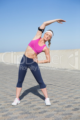 Fit blonde stretching on the pier