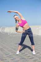 Fit blonde stretching on the pier