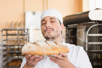 Baker smelling freshly baked loaf