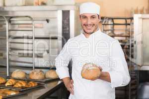 Baker holding a freshly baked loaf