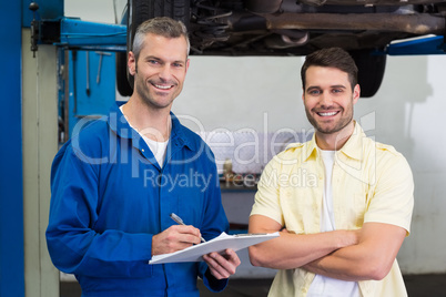 Customer and mechanic smiling at camera