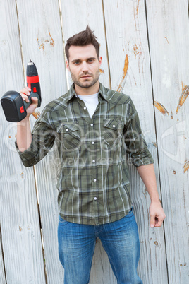 Confident carpenter holding hand drill