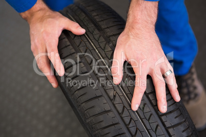 Mechanic rolling a tire wheel