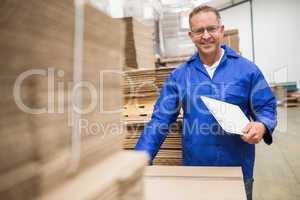 Warehouse worker checking his list on clipboard