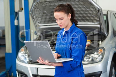 Mechanic using laptop on car