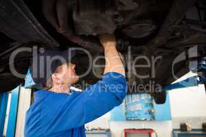 Mechanic examining under the car