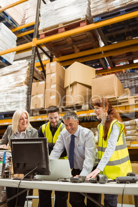 Warehouse team working together on laptop