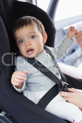 Mother securing her baby in the car seat