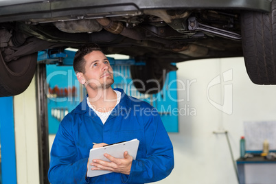 Mechanic examining under the car