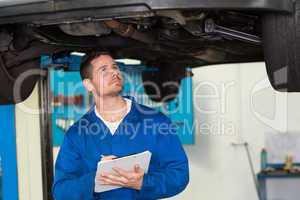 Mechanic examining under the car