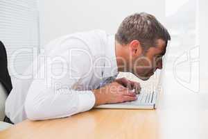 Confused businessman looking at his laptop