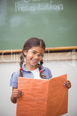 Cute pupil smiling at camera during class presentation