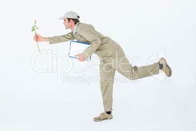 Delivery man with clipboard offering flower