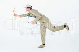 Delivery man with clipboard offering flower