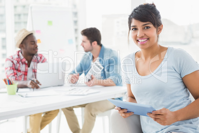 Smiling businesswoman holding tablet on couch