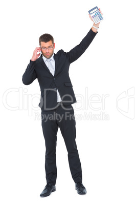 Businessman on the phone holding up calculator Businessman on the phone holding up calculator