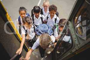Cute schoolchildren getting on school bus