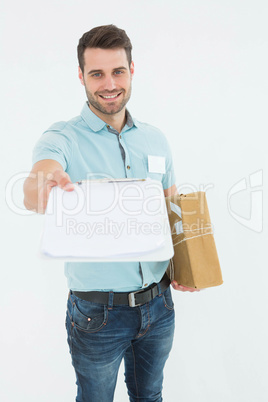 Delivery man with package giving clipboard for signature