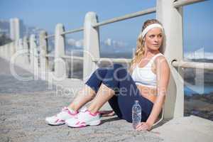 Fit blonde sitting on the pier