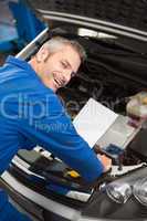 Mechanic examining under hood of car