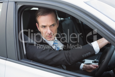 Unsmiling businessman in the drivers seat