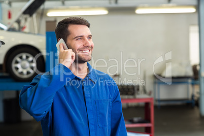 Smiling mechanic on the phone