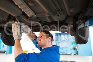 Mechanic examining under the car