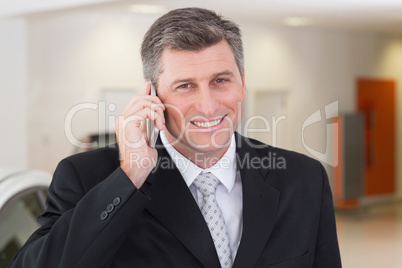 Smiling businessman calling with his mobile phone