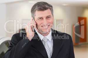 Smiling businessman calling with his mobile phone