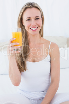 Smiling blonde holding glass of orange juice