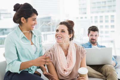 Smiling businesswomen chatting together on couch