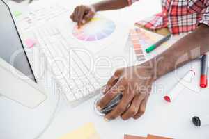 Businessman pointing colour wheel and using mouse