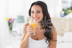Happy brunette having glass of orange