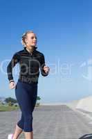 Fit blonde jogging on the pier