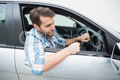 Young man smiling and driving