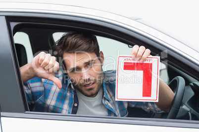 Learner driver smiling and holding l plate