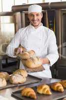 Happy baker showing tray of fresh bread