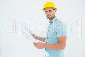 Confident male architect holding blueprint