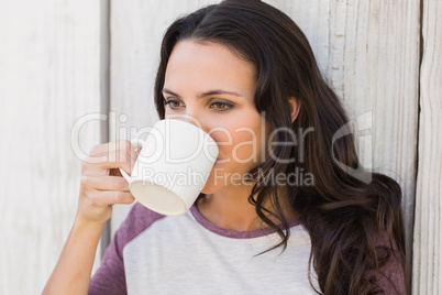 Pretty brunette drinking from mug