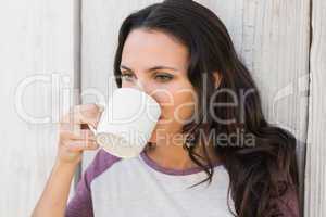 Pretty brunette drinking from mug