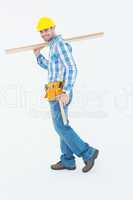 Smiling worker carrying wooden planks